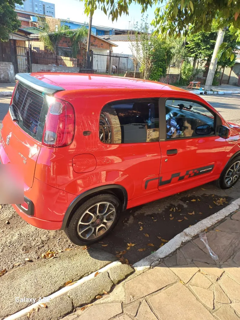 Carro vermelho compacto de cliente com a lataria brilhando ao sol